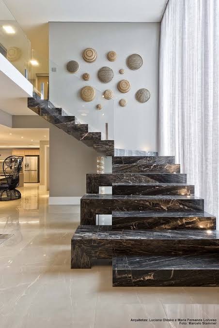 Escada residencial revestida em pedra escura